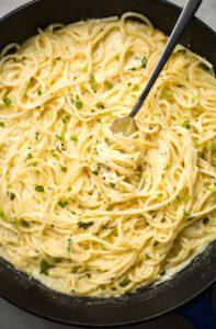 Creamy Garlic Parmesan Spaghetti Indulge in the creamy, rich flavors of this Creamy Garlic Parmesan Spaghetti! With its velvety sauce, savory garlic, and a hint of cheesy goodness, this dish is both simple and luxurious—a perfect choice for a cozy dinner or when you want to impress your guests without too much effort. Ingredients 12 oz (340 g) spaghetti 3 tbsp unsalted butter 4 garlic cloves, minced 2 cups heavy cream 1/2 cup grated Parmesan cheese (plus extra for garnish) 1/4 tsp nutmeg (optional, for depth) Salt and freshly ground black pepper, to taste 2 tbsp chopped fresh parsley or chives, for garnish Instructions Cook the spaghetti: Bring a large pot of salted water to a boil. Cook the spaghetti according to package instructions until al dente. Reserve 1 cup of pasta water, then drain and set aside. Make the garlic base: In a large skillet over medium heat, melt the butter. Add the minced garlic and sauté for 1–2 minutes until fragrant (be careful not to burn). Prepare the creamy sauce: Reduce the heat to low and stir in the heavy cream. Let it gently simmer for 2–3 minutes. Stir in the Parmesan cheese and nutmeg (if using). Allow the sauce to thicken slightly, stirring occasionally. Season and combine: Add the cooked spaghetti to the skillet. Toss to coat the pasta in the creamy sauce. If the sauce is too thick, use the reserved pasta water, adding a little at a time, until you achieve your desired consistency. Adjust the flavors: Season with salt and freshly ground black pepper to taste. Garnish and serve: Transfer the spaghetti to serving plates. Sprinkle with additional Parmesan cheese and garnish with chopped parsley or chives. Serve immediately and enjoy! Conclusion This Creamy Garlic Parmesan Spaghetti is a quick yet decadent meal that brings restaurant-quality flavors to your home kitchen. Pair it with a fresh green salad or garlic bread for a complete feast, and savor every creamy, garlicky bite!